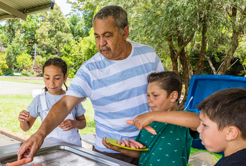 Father and children use barbecue