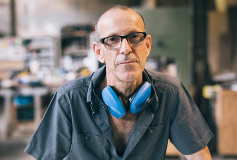 Man with glasses and earmuffs in workplace