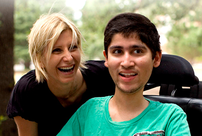 Man in wheelchair and carer smiling