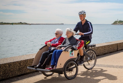 Elderly women sit on the front of a custom made bike