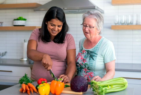 women cook vegetables together